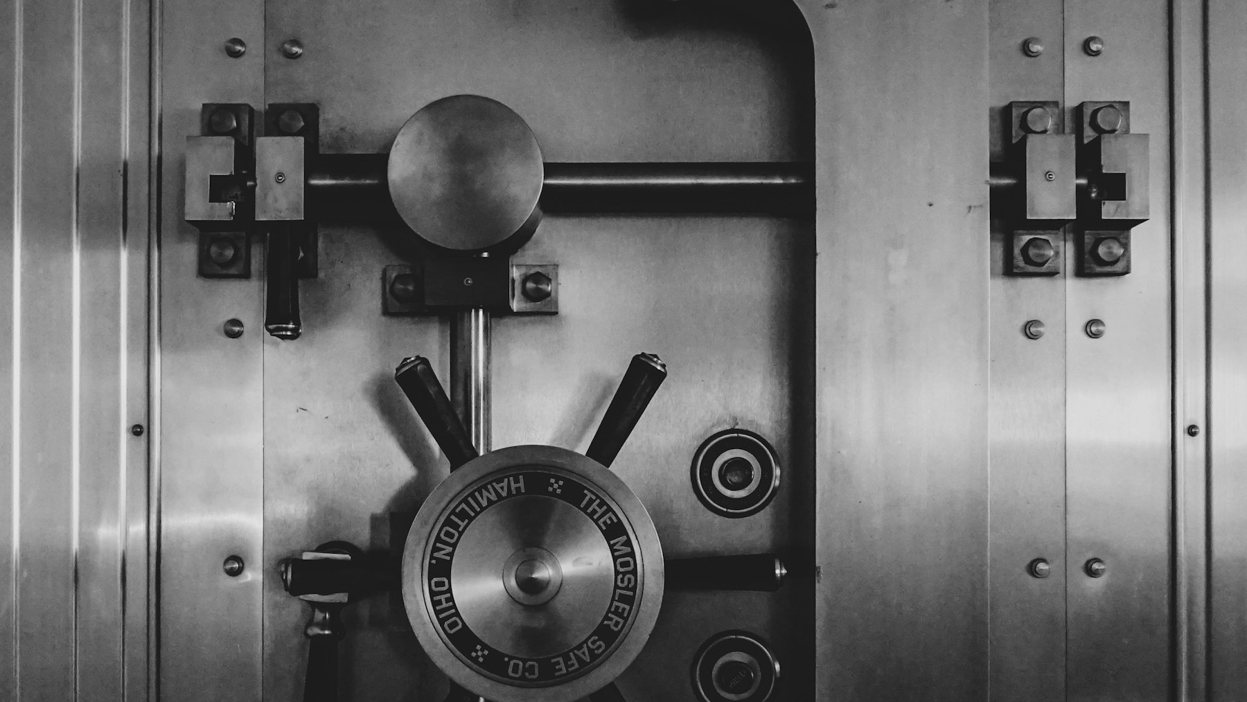 A heavy steel vault door with a circular locking wheel