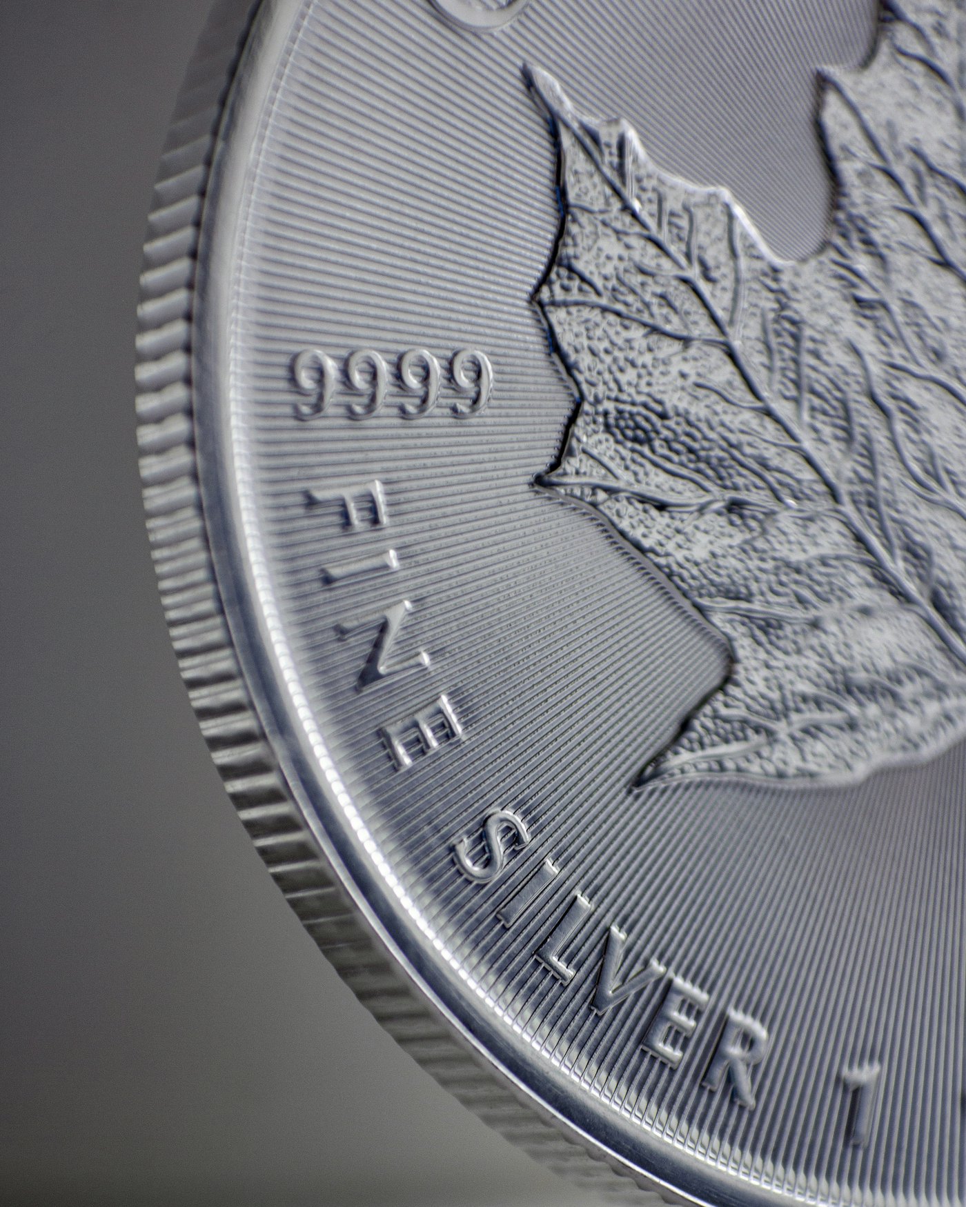 Close-up of the maple leaf and .9999 fineness mark on a silver bullion coin